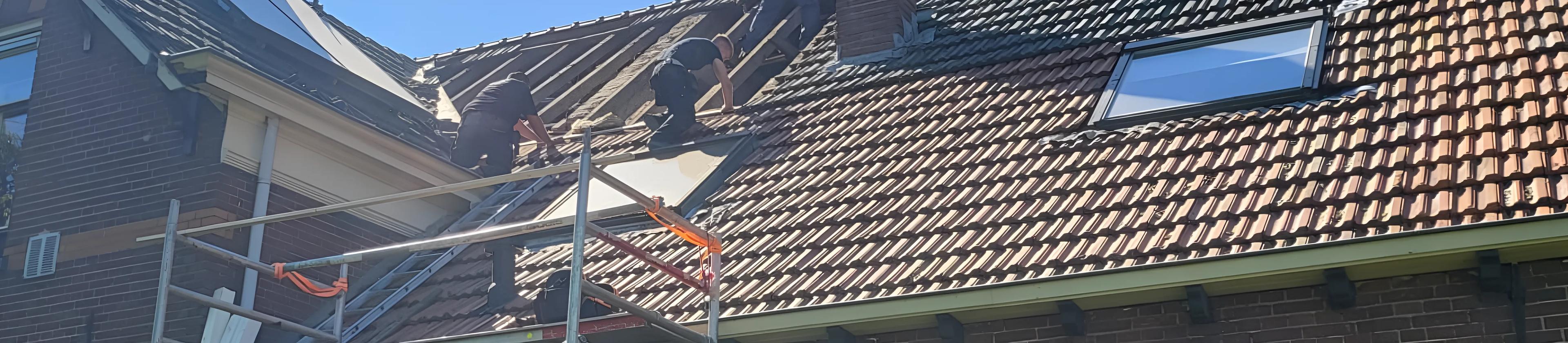 Dakdekkers van Van Dooren aan het werk op een pannendak
